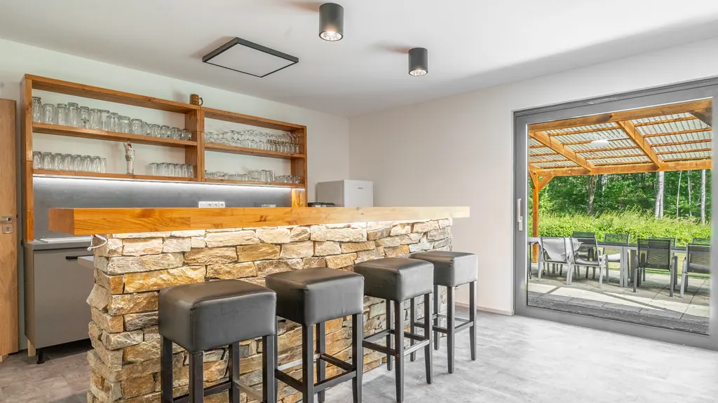 Bar s kamenným pultem a barovými židlemi